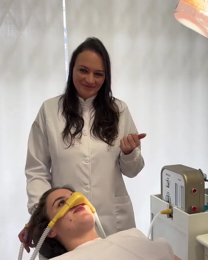 Paciente relaxada com a máscara nasal de óxido nitroso, acompanhada pela dentista, no consultório da Gabardo Odontologia